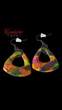 Load image into Gallery viewer, Pair of colorful polymer clay dangle earrings with pumpkin motifs and black hooks on a black background