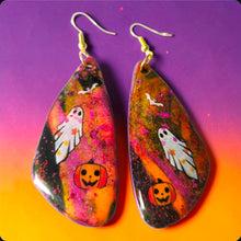 Load image into Gallery viewer, Pair of colorful ghost, bat, and pumpkin Halloween earrings displayed on a white plate
