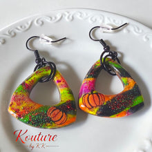 Load image into Gallery viewer, Pair of handmade polymer clay pumpkin earrings with colorful stripes, glitter, and black hooks
