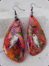 Load image into Gallery viewer, Handmade Halloween earrings featuring a white ghost and black spiderweb design on glittery pink and orange teardrops with black hooks

