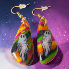 Load image into Gallery viewer, Pair of colorful polymer clay ghost drop earrings photographed on a purple starry background
